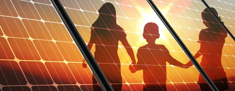 View of silhouette of children standing in front of solar panels.